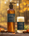 Herbal Alchemy body wash and cream on a wooden log with a forest background
