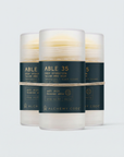 Three containers of Alchemy Code skincare product on a white background