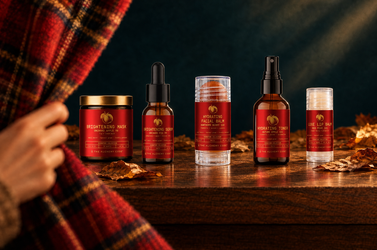 A hand pulls a red tartan cloth aside to reveal the five Orchard Face bottles